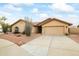 Tan house with two-car garage and desert landscaping at 13454 N 88Th Pl, Scottsdale, AZ 85260