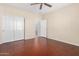 Bedroom with wood floors and double doors to closet at 15041 W Wrigley Way, Surprise, AZ 85374