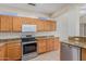 Well-equipped kitchen with granite counters and wood cabinets at 15041 W Wrigley Way, Surprise, AZ 85374