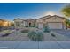 One-story home with stone accents, a three-car garage, and desert landscaping at 18059 W Tierra Del Sol Dr, Surprise, AZ 85387