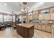 Island kitchen with granite counters, light wood cabinets, and breakfast bar at 18059 W Tierra Del Sol Dr, Surprise, AZ 85387