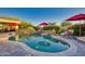 Inviting kidney-shaped pool with red umbrellas and lounge chairs at 18059 W Tierra Del Sol Dr, Surprise, AZ 85387