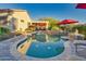 Relaxing kidney-shaped pool with red umbrellas and lounge chairs at 18059 W Tierra Del Sol Dr, Surprise, AZ 85387