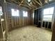 Spacious bedroom featuring wooden framing, three windows providing natural light, and plywood flooring at 22820 E Lords Way, Queen Creek, AZ 85142