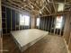 Spacious bedroom featuring wooden framing, three windows providing natural light, and drywall for installation at 22820 E Lords Way, Queen Creek, AZ 85142