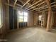 Unfinished interior of room under construction with exposed wooden framing, a window, and concrete flooring at 22820 E Lords Way, Queen Creek, AZ 85142