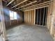 Unfinished interior of room under construction with exposed wooden framing, a window, and concrete flooring at 22820 E Lords Way, Queen Creek, AZ 85142
