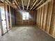 A room under construction features exposed wooden framing, a window, and concrete flooring with markings at 22820 E Lords Way, Queen Creek, AZ 85142