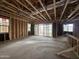 Unfinished living room under construction featuring exposed framing, large windows, and a sliding glass door at 22820 E Lords Way, Queen Creek, AZ 85142
