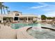 Expansive backyard featuring a pool, spa, covered patio, and lush landscaping, perfect for outdoor entertaining at 321 N Portland Ave, Gilbert, AZ 85234