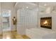 Bright bathroom features a glass block wall, soaking tub, and cozy fireplace at 321 N Portland Ave, Gilbert, AZ 85234