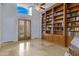 Bright home office featuring a large bookcase and natural light at 321 N Portland Ave, Gilbert, AZ 85234