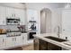 A bright kitchen features stainless steel appliances, granite countertops and sleek white cabinetry at 321 N Portland Ave, Gilbert, AZ 85234