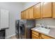 Laundry room with cabinets above stainless steel washer and dryer and utility sink at 321 N Portland Ave, Gilbert, AZ 85234