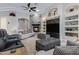 Comfortable living room with a gray brick fireplace, built-in shelving, and a ceiling fan at 321 N Portland Ave, Gilbert, AZ 85234
