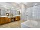 Main bathroom with double vanities, granite counters, glass block shower, and soaking tub at 321 N Portland Ave, Gilbert, AZ 85234