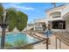 Backyard pool featuring volleyball and basketball, as well as an outdoor kitchen, seating, and manicured landscaping at 321 N Portland Ave, Gilbert, AZ 85234