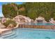 Backyard pool featuring a natural rock waterfall and slide, surrounded by lush greenery at 321 N Portland Ave, Gilbert, AZ 85234