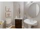 Charming powder room with decorative mirror, flowers, and pedestal sink at 321 N Portland Ave, Gilbert, AZ 85234