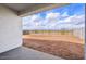 A spacious backyard has a dirt lot, partial brick wall, and partial metal fencing at 4312 E Bradford Ave, San Tan Valley, AZ 85143
