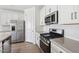 Modern kitchen featuring stainless steel appliances, white cabinetry, and gray countertops at 4312 E Bradford Ave, San Tan Valley, AZ 85143