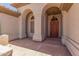Elegant entryway with arched columns and a rich wood door at 5535 E Sheena Dr, Scottsdale, AZ 85254