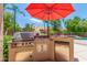 Outdoor kitchen features a built-in grill, refrigerator, and granite countertops at 5535 E Sheena Dr, Scottsdale, AZ 85254