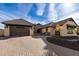Tan house with brown roof and brick driveway; nicely landscaped at 7130 W Rowel Rd, Peoria, AZ 85383