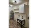 Laundry room with utility sink, upper cabinets, and wood-look floors at 12432 W Fieldstone Dr, Sun City West, AZ 85375