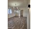 Bright and airy living room with wood-look floors and modern chandelier at 12432 W Fieldstone Dr, Sun City West, AZ 85375