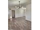 Open living room with wood-look floors and modern light fixture at 12432 W Fieldstone Dr, Sun City West, AZ 85375
