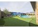 Backyard oasis with a sparkling pool, putting green, and tropical mural at 15834 S 177Th Ave, Goodyear, AZ 85338