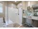 Modern bathroom with a walk-in shower, soaking tub, and vanity area at 15834 S 177Th Ave, Goodyear, AZ 85338