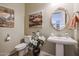 Elegant powder room with pedestal sink and decorative mirror at 15834 S 177Th Ave, Goodyear, AZ 85338