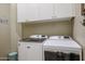 Bright laundry room, featuring a washer and dryer with updated cabinetry at 15834 S 177Th Ave, Goodyear, AZ 85338