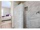 Clean shower with marble-like tiles and a small pebble accent at 15834 S 177Th Ave, Goodyear, AZ 85338