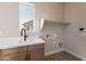 New laundry room features cabinets, sleek countertops, and a window with a view at 17251 W Montpelier St, Surprise, AZ 85388