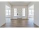 Spacious entryway with light wood-look tile floors, white walls, and multiple windows at 17394 W Sugar Hill Ct, Surprise, AZ 85388