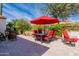 Relaxing patio with seating area under a red umbrella and a stone water feature at 1806 E Azafran Trl, Queen Creek, AZ 85140