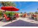 Outdoor patio area with seating, a red umbrella, and a built-in grill at 1806 E Azafran Trl, Queen Creek, AZ 85140