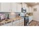 White kitchen with granite countertops and stainless steel appliances at 1806 E Azafran Trl, Queen Creek, AZ 85140