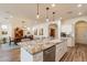 Open concept kitchen with granite island, white cabinets, and hardwood floors at 1806 E Azafran Trl, Queen Creek, AZ 85140