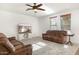 Living room with brown leather couches and a large TV at 18437 W Sunnyslope Ln, Waddell, AZ 85355