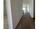 Hallway showcasing wood-look floors leading to kitchen with natural light at 22836 E Lords Way, Queen Creek, AZ 85142