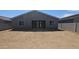 The exterior of the home is painted gray and has a dirt backyard with a gray block wall at 2690 E Abe Truckle Ave, San Tan Valley, AZ 85140