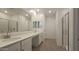 Bathroom featuring double sinks, framed mirrors, tile flooring, and a glass enclosed shower at 2690 E Abe Truckle Ave, San Tan Valley, AZ 85140
