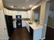 Modern kitchen featuring white cabinets, black appliances, and quartz countertops at 3865 E Santa Fe Ln, Gilbert, AZ 85297