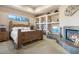 Spacious bedroom with a large wooden bed frame and a fireplace at 39816 N 106Th Pl, Scottsdale, AZ 85262