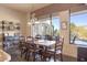 Bright dining area with a large window showcasing scenic views and a rustic wooden table at 39816 N 106Th Pl, Scottsdale, AZ 85262