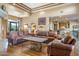 Spacious living room with leather sofas, hardwood floors, and a stone fireplace at 39816 N 106Th Pl, Scottsdale, AZ 85262